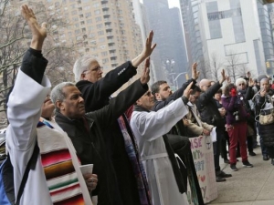 New Sanctuary Coalition and supporters pray in front of the Trump International Hotel in New York, Thursday, March 29, 2018. (Photo: Seth Wenig, AP)